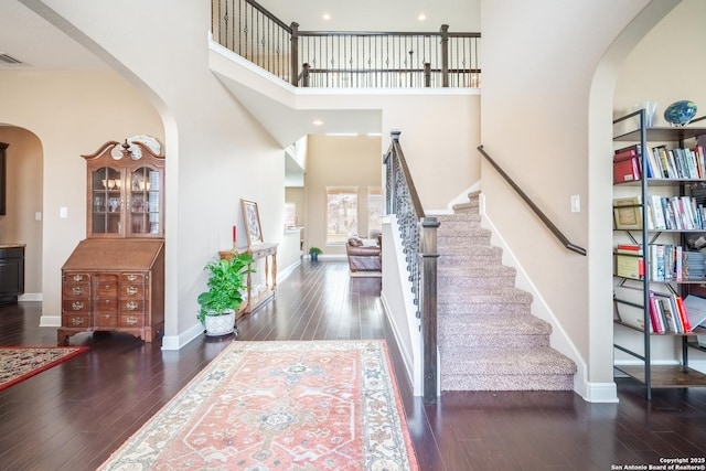 foyer entrance with dark hardwood / wood-style flooring and a high ceiling