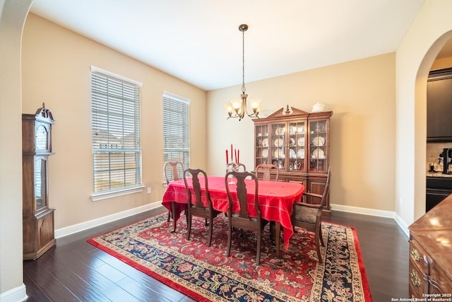 dining area with dark hardwood / wood-style floors and a chandelier