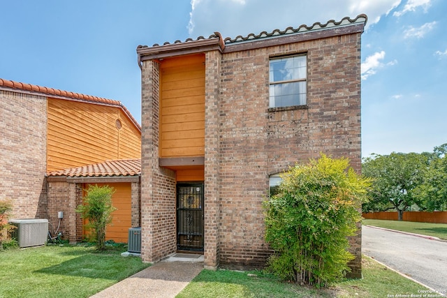 view of front of property featuring central AC and a front yard