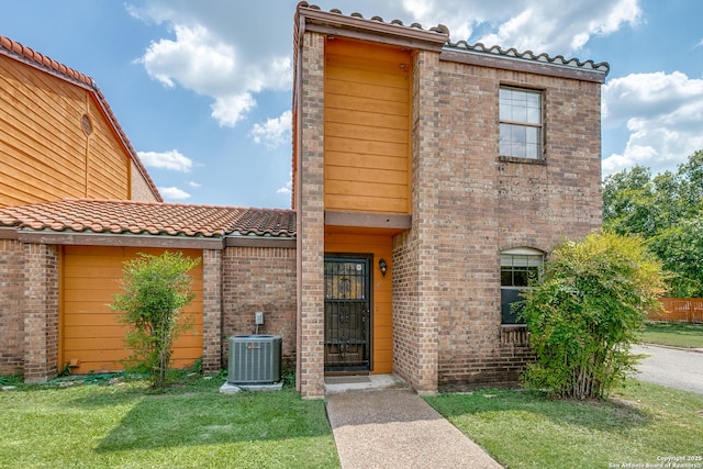 view of front of home featuring a front yard and central air condition unit