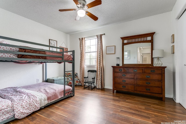 bedroom featuring dark wood-type flooring, ceiling fan, and a textured ceiling