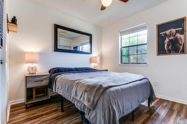 bedroom with ceiling fan, dark wood-type flooring, and a textured ceiling