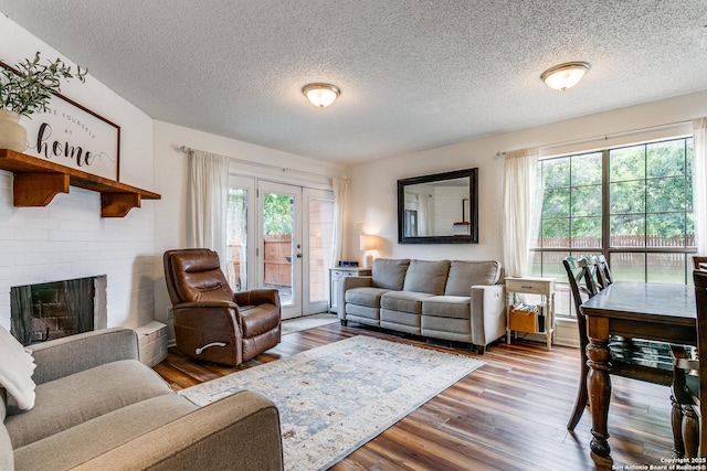 living room with a fireplace, wood-type flooring, french doors, and plenty of natural light