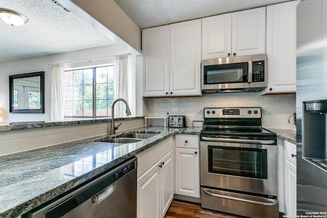 kitchen with white cabinetry, sink, decorative backsplash, and appliances with stainless steel finishes