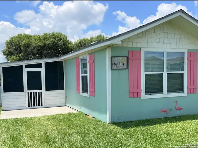 view of side of home featuring a yard and a patio area