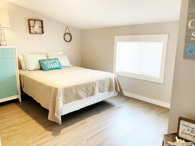 bedroom with hardwood / wood-style flooring and vaulted ceiling