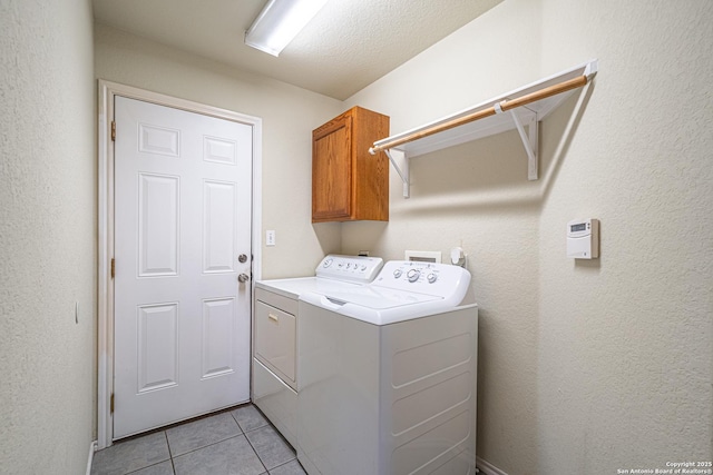 laundry area with cabinets, light tile patterned floors, and independent washer and dryer