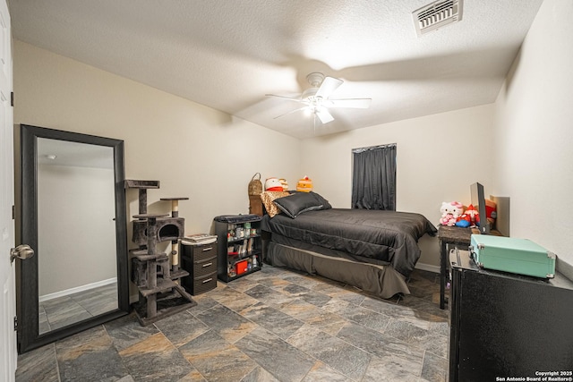 bedroom with a textured ceiling and ceiling fan