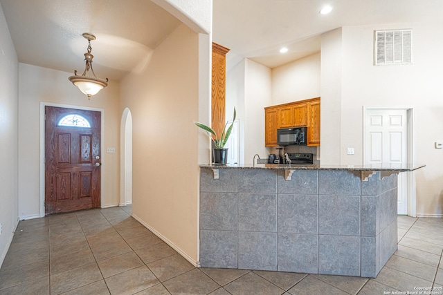 entrance foyer featuring light tile patterned flooring and a high ceiling