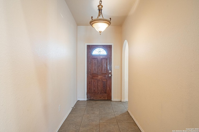 doorway to outside featuring dark tile patterned flooring