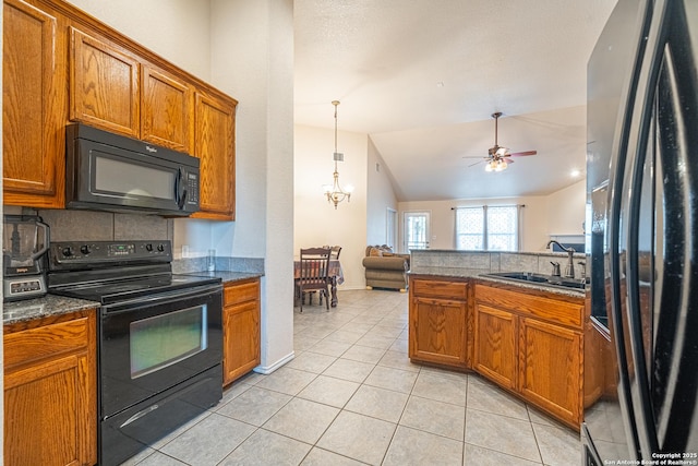 kitchen with lofted ceiling, sink, light tile patterned floors, black appliances, and ceiling fan with notable chandelier