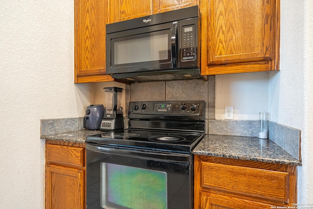 kitchen featuring backsplash, dark stone counters, and black appliances