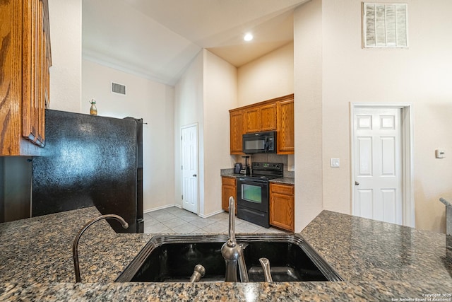 kitchen featuring dark stone countertops, sink, high vaulted ceiling, and black appliances