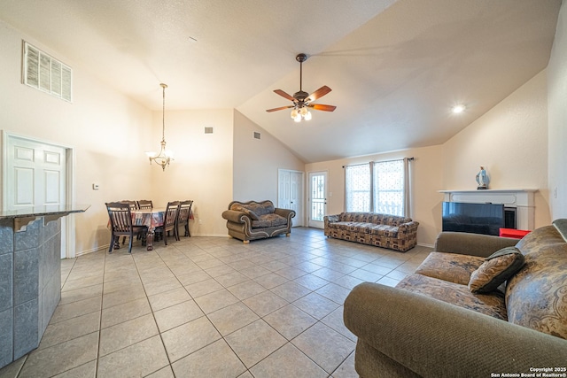 tiled living room featuring ceiling fan with notable chandelier and high vaulted ceiling