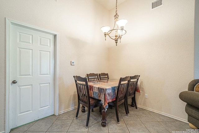 dining area featuring lofted ceiling, light tile patterned floors, and an inviting chandelier