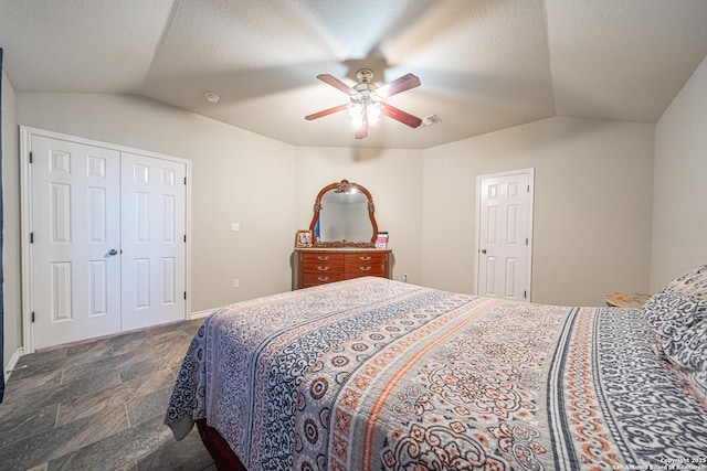 bedroom with lofted ceiling, a textured ceiling, and ceiling fan