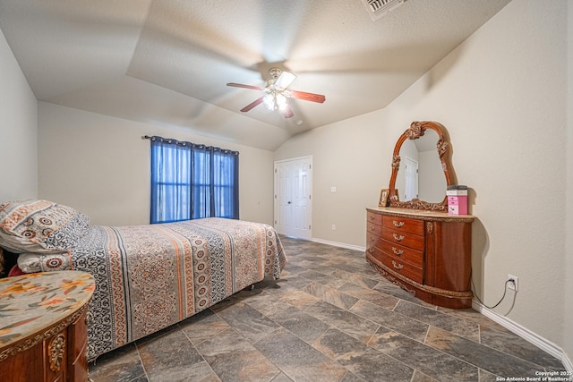 bedroom featuring ceiling fan, lofted ceiling, and a textured ceiling