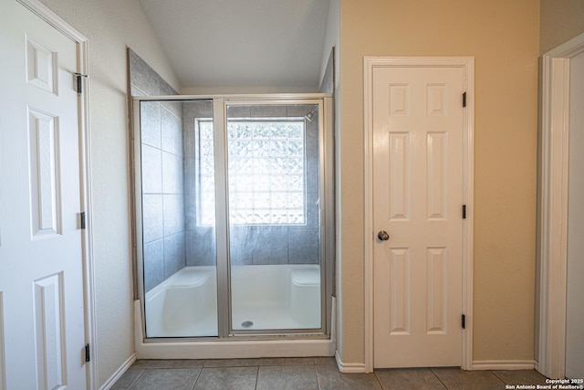 bathroom featuring a shower with shower door and tile patterned floors