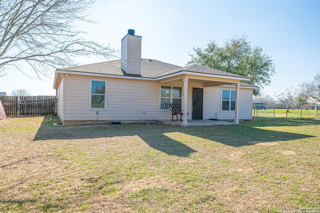 rear view of house with a yard and a patio area