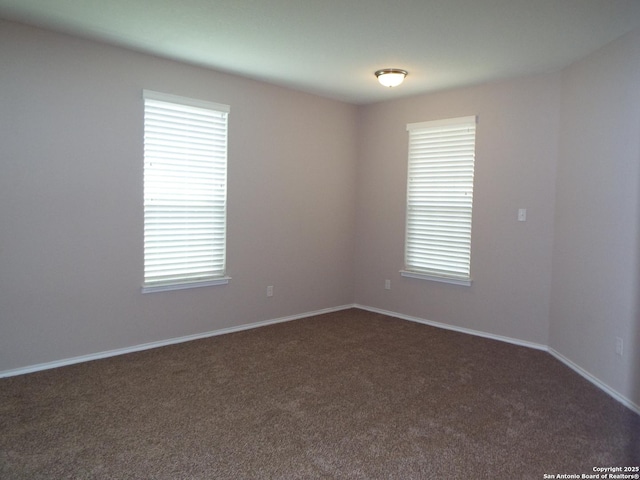 spare room featuring dark carpet