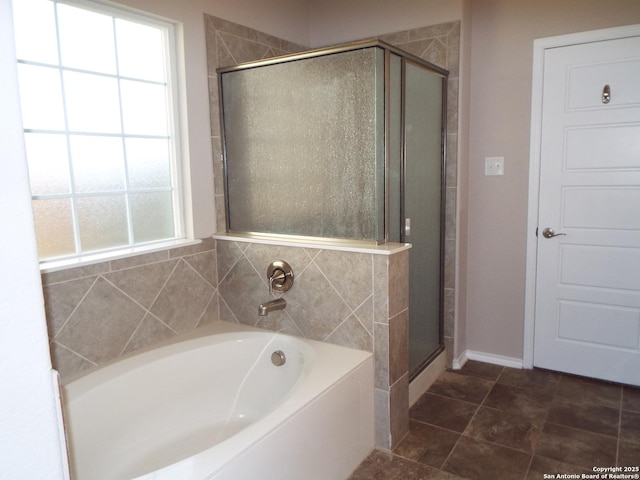 bathroom with tile patterned flooring, separate shower and tub, and a healthy amount of sunlight