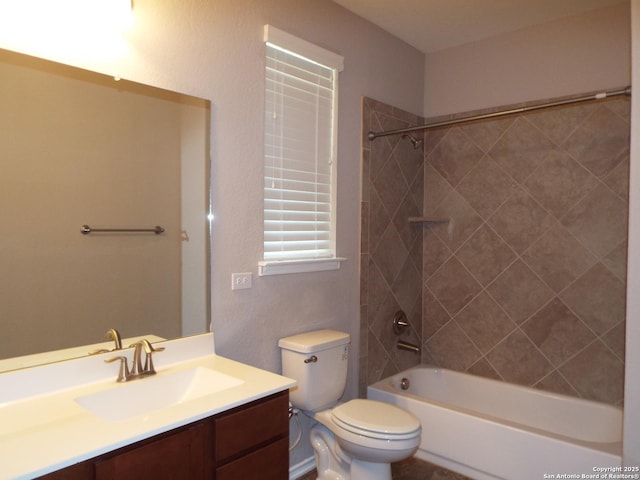 full bathroom featuring tiled shower / bath combo, vanity, and toilet