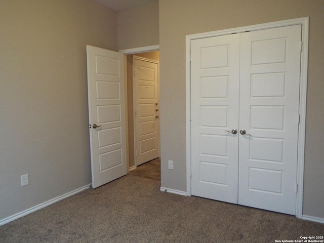 unfurnished bedroom featuring dark carpet and a closet