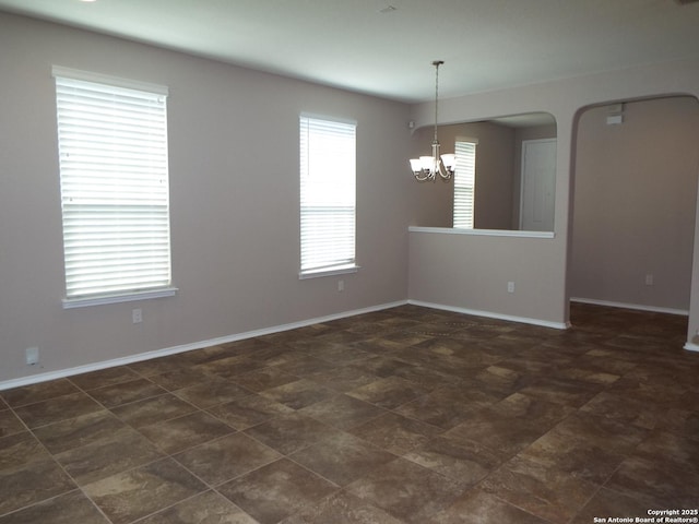 spare room featuring a notable chandelier