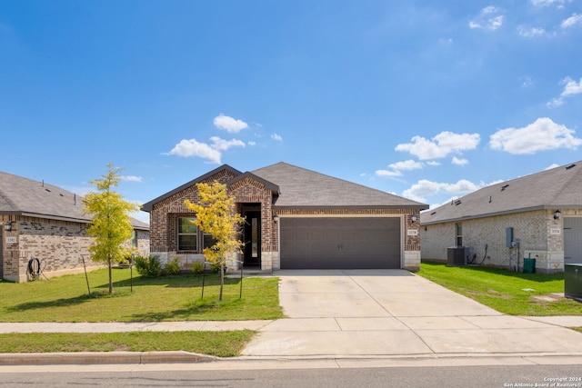 view of front of property featuring a garage, a front yard, and central air condition unit