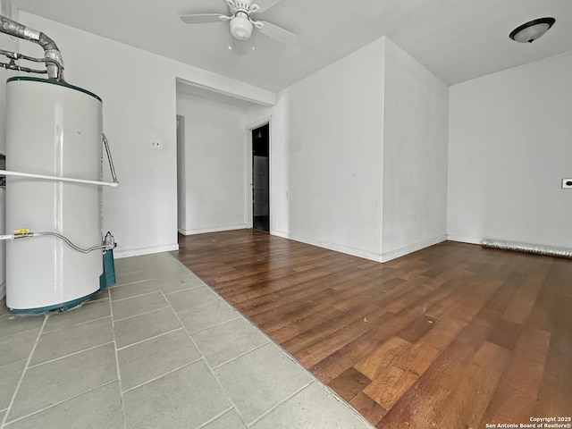 unfurnished living room with wood-type flooring, water heater, and ceiling fan