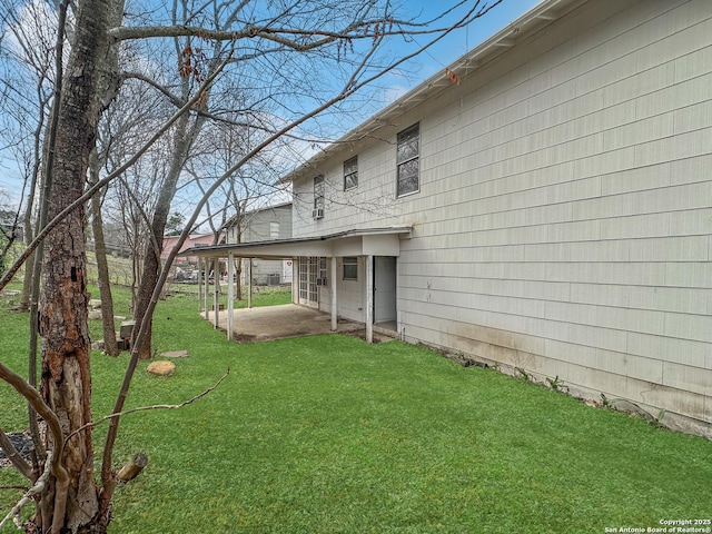 back of house with a patio and a lawn