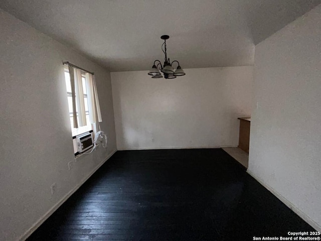 unfurnished dining area with dark wood-type flooring and a chandelier