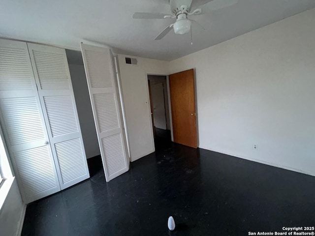 unfurnished bedroom featuring ceiling fan and a closet