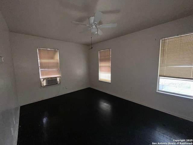 unfurnished room with cooling unit, ceiling fan, and wood-type flooring