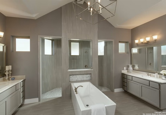 bathroom with vanity, separate shower and tub, vaulted ceiling, and a notable chandelier