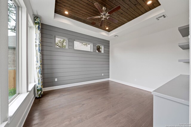 unfurnished sunroom featuring a tray ceiling, wooden ceiling, and a healthy amount of sunlight