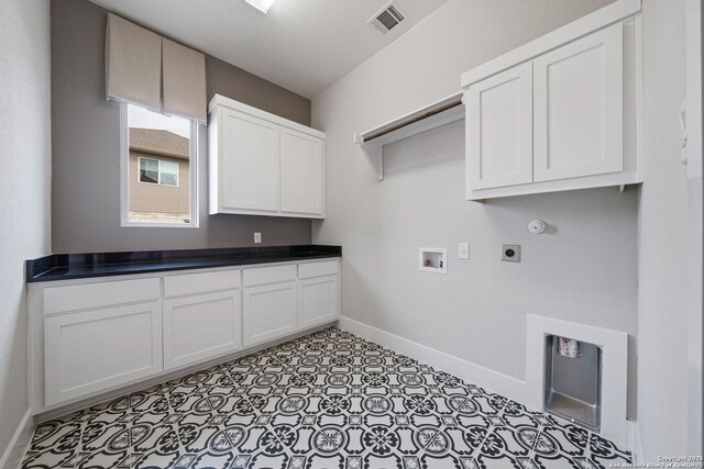 clothes washing area featuring cabinets, hookup for a washing machine, and hookup for an electric dryer