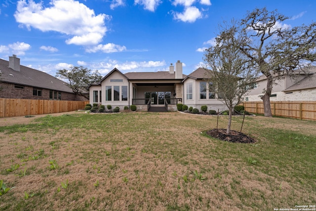 rear view of house with a yard and ceiling fan