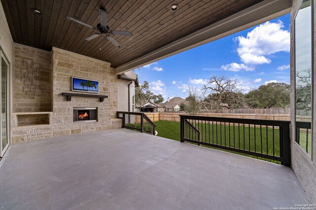 view of patio / terrace with ceiling fan and an outdoor stone fireplace