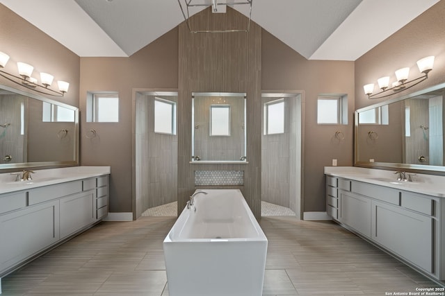 bathroom with vanity, independent shower and bath, and vaulted ceiling