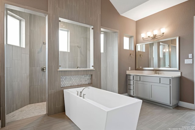 bathroom with independent shower and bath, vanity, and plenty of natural light