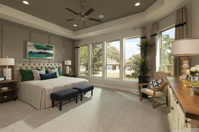 bedroom with a raised ceiling and ceiling fan