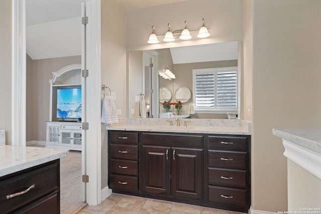 bathroom with lofted ceiling and vanity