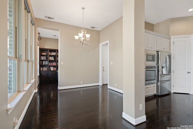 kitchen featuring stainless steel appliances, white cabinetry, dark wood finished floors, and visible vents