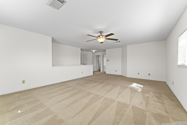 carpeted spare room featuring a textured ceiling and ceiling fan