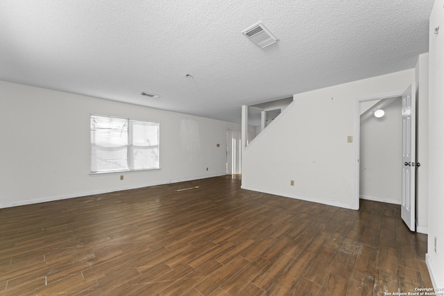 empty room featuring dark hardwood / wood-style floors and a textured ceiling