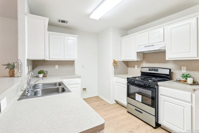 kitchen with stainless steel range with gas cooktop, white cabinets, a sink, and under cabinet range hood