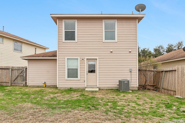 back of property featuring central air condition unit, a fenced backyard, a gate, and a yard