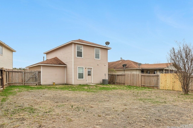 rear view of house featuring central AC and a fenced backyard