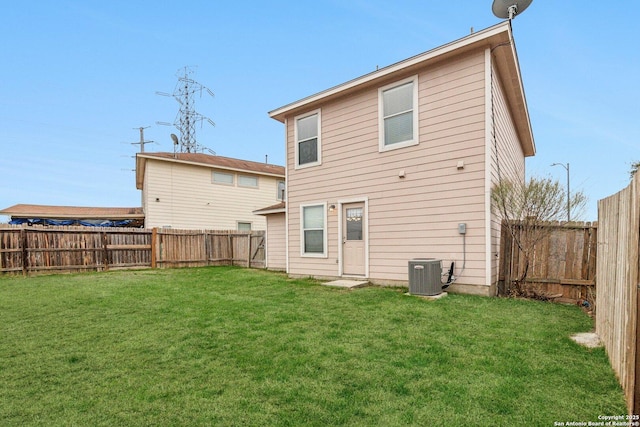 rear view of house featuring central AC, a lawn, and a fenced backyard